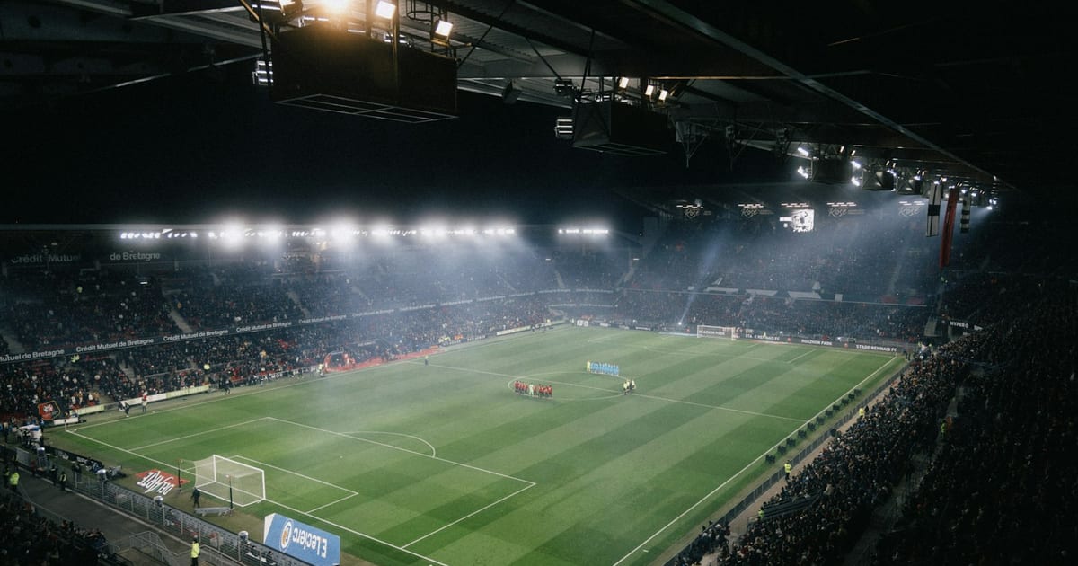 Uno stadio di calcio illuminato di notte: i club di Serie A convivono con miliardi di debiti senza fallire